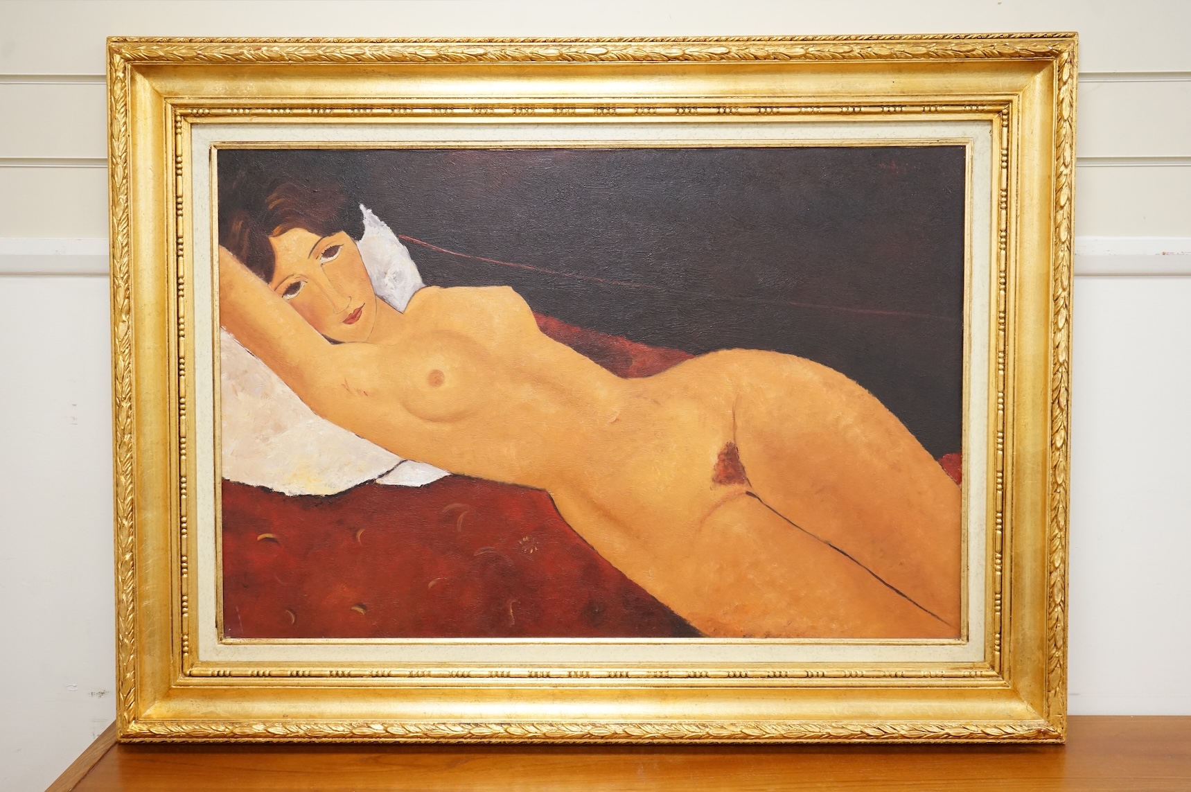 In the manner Amedeo Modigliani (Italian, 1884-1920), oil on canvas, Study of a reclining nude woman, inscription and COA verso, gilt framed, 59 x 90cm